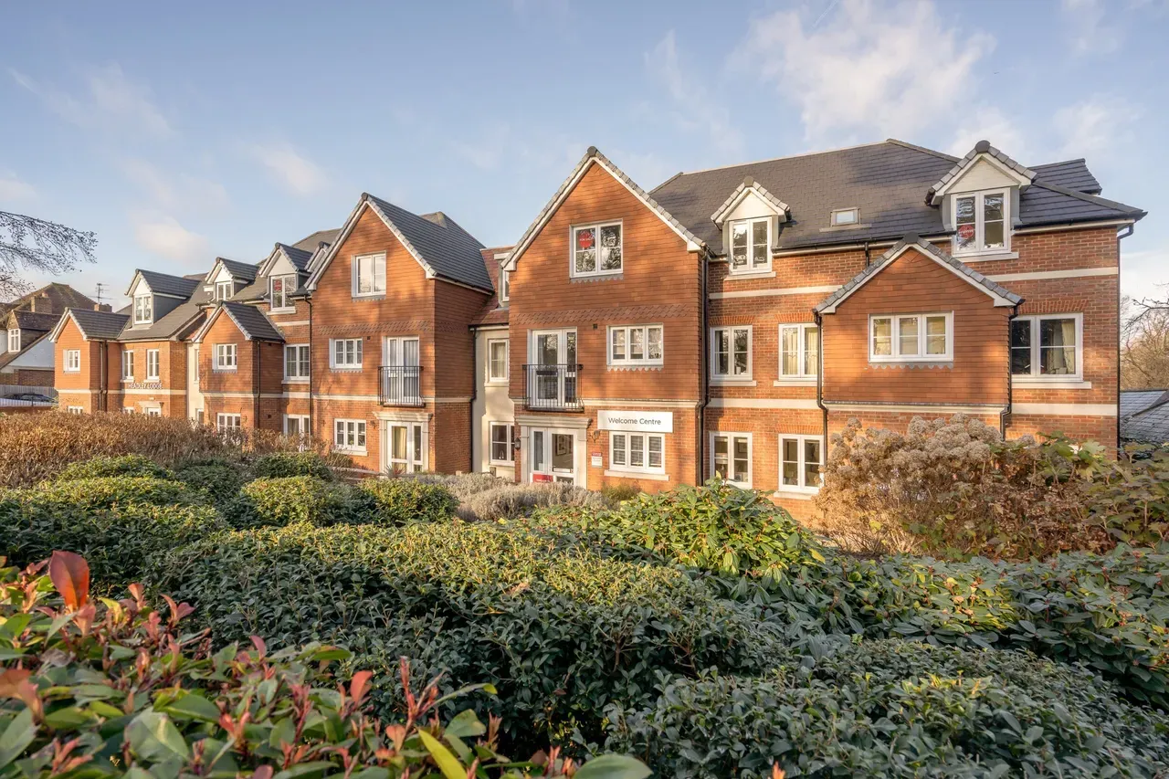 Brick building behind hedges